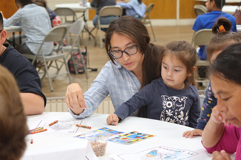 A mom and daughter play Lotería, a Bingo-style game that originated in Mexico.