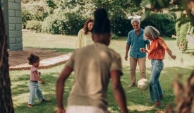 A multi-generation family plays soccer outside