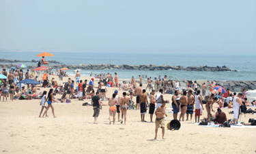 Visitors frolic in the surf and sun at Rockaway Beach in Queens, New York City.  Visitors frolic in the surf and sun at Rockaway Beach in Queens, New York City.